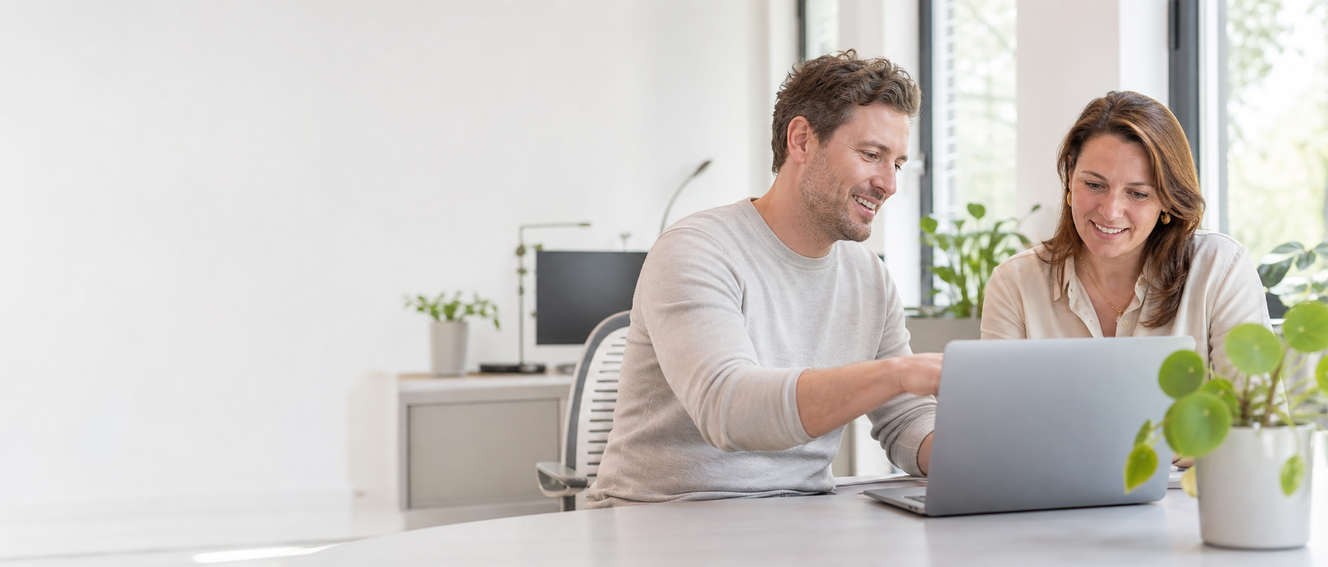 Samen werken aan een laptop in een lichte kantooromgeving